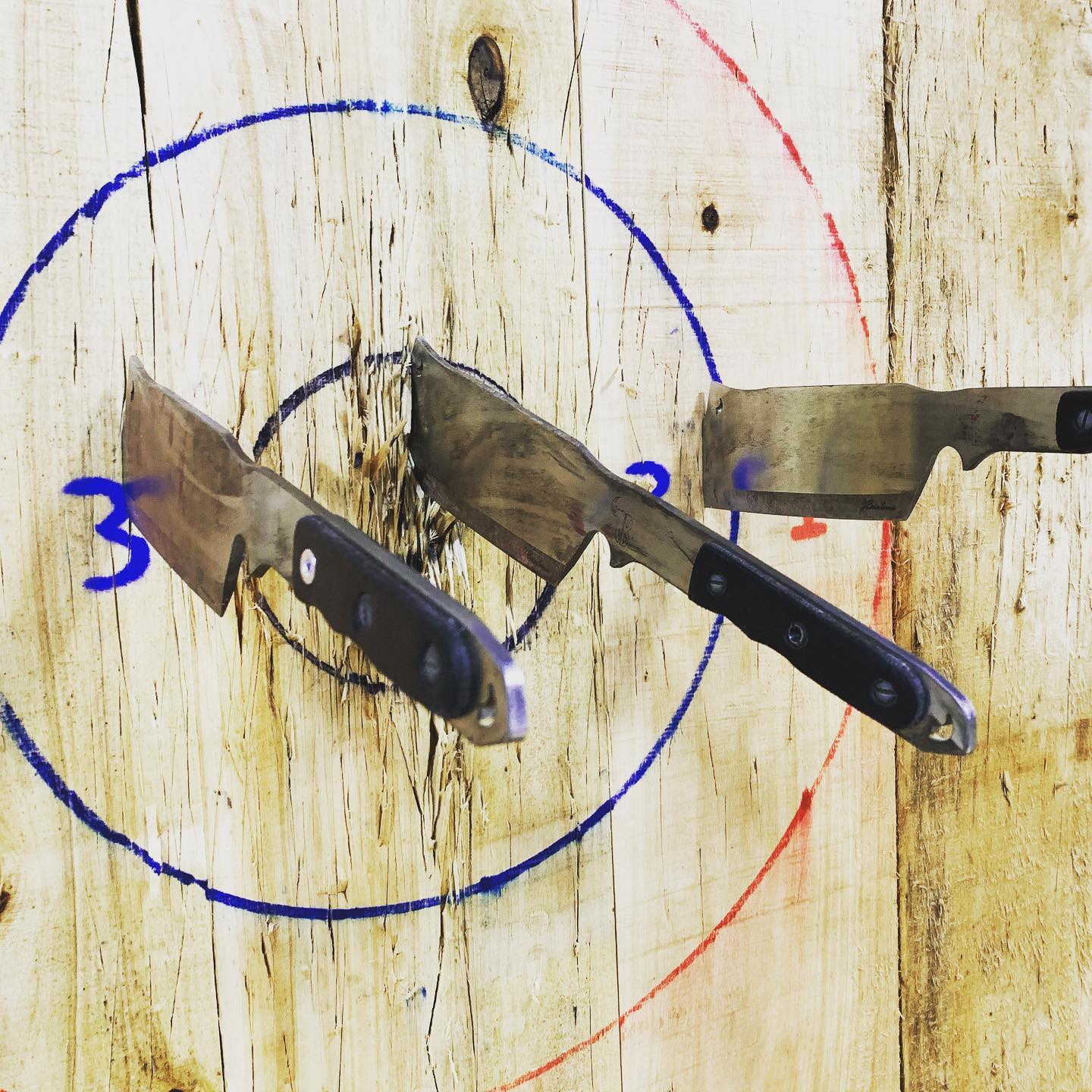Three throwing knives stuck in a numbered target