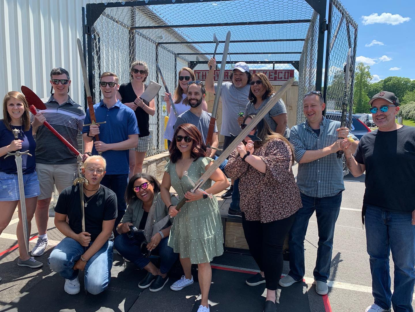A corporate group hamming it up with throwing gear in the sun