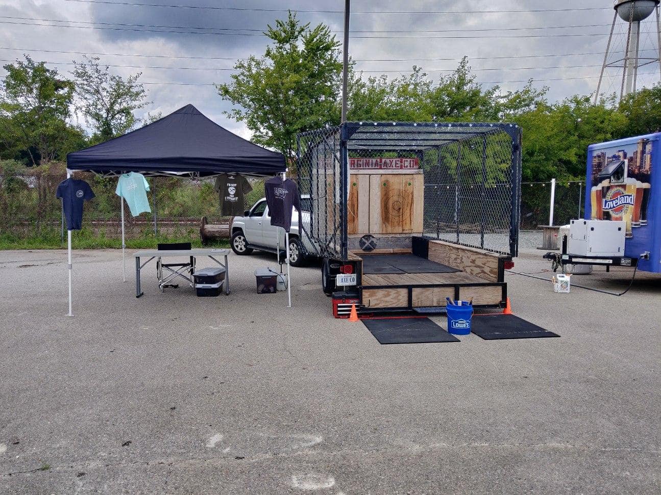 Event setup with canopy and merch beside a craft beer truck