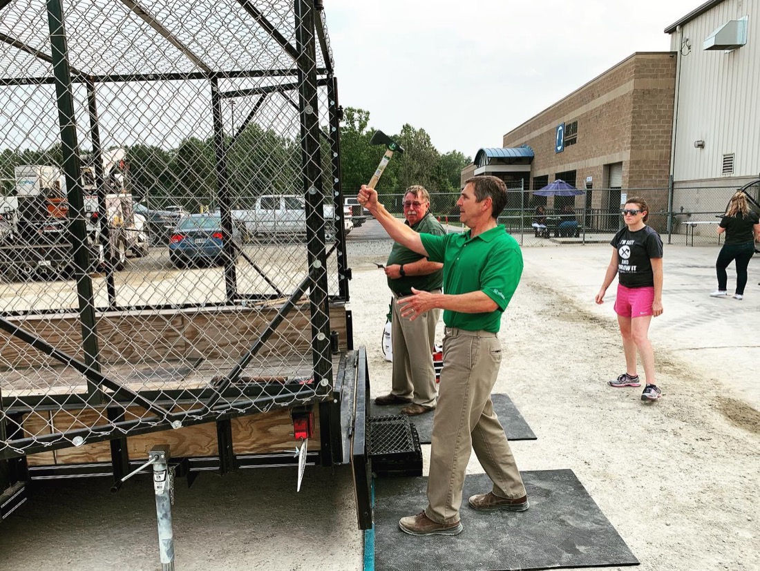 A guest releasing a throw while the coach watches the lane