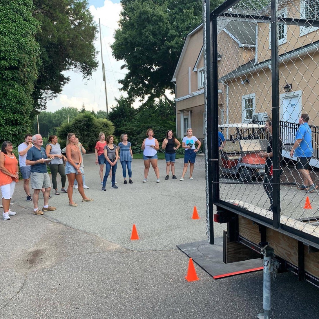 Guests watching throws from a driveway at a neighborhood event