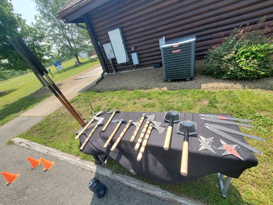 The throwing arsenal laid out on a table at a log cabin venue
